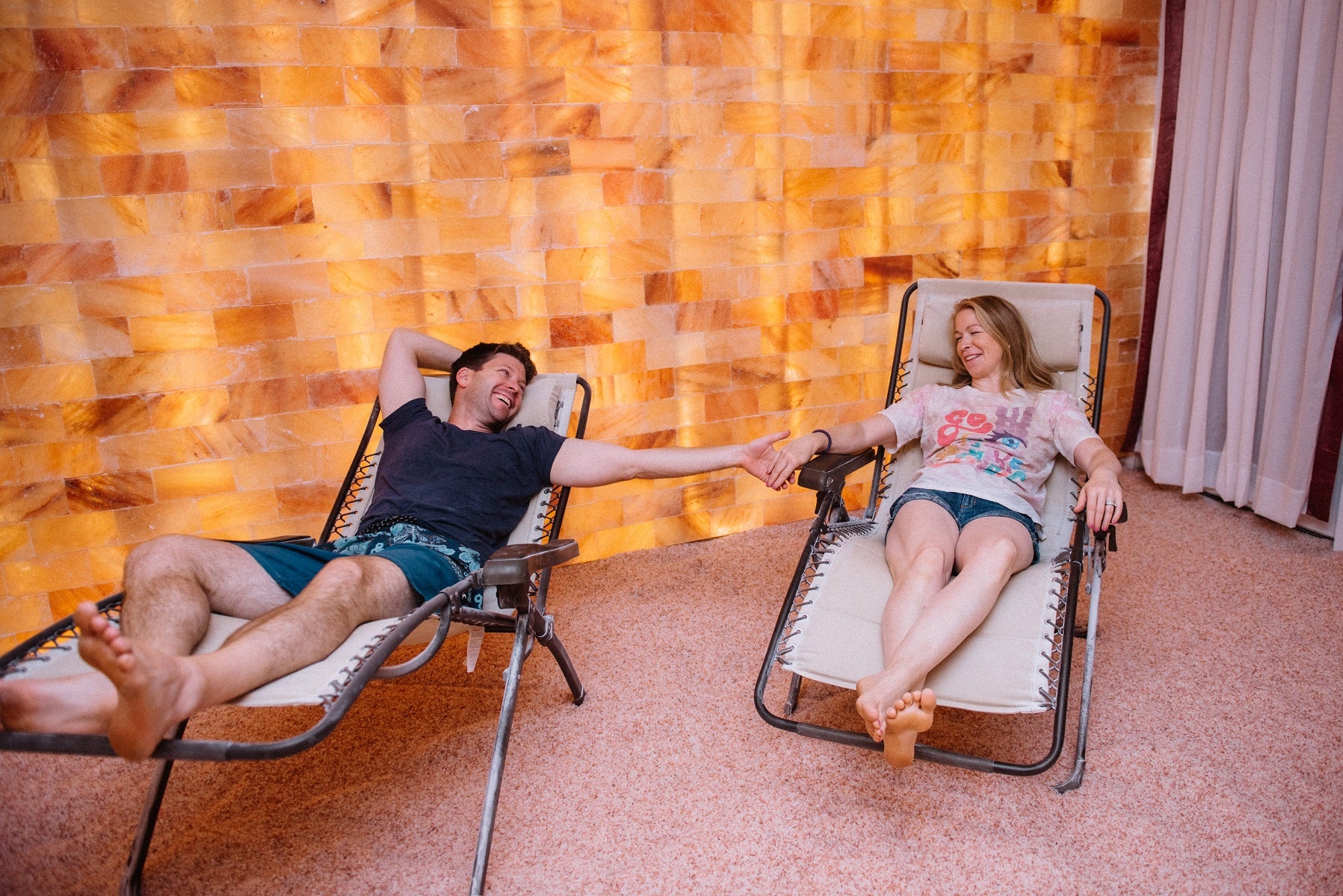 Couple holding hands enjoying the Himalayan salt room