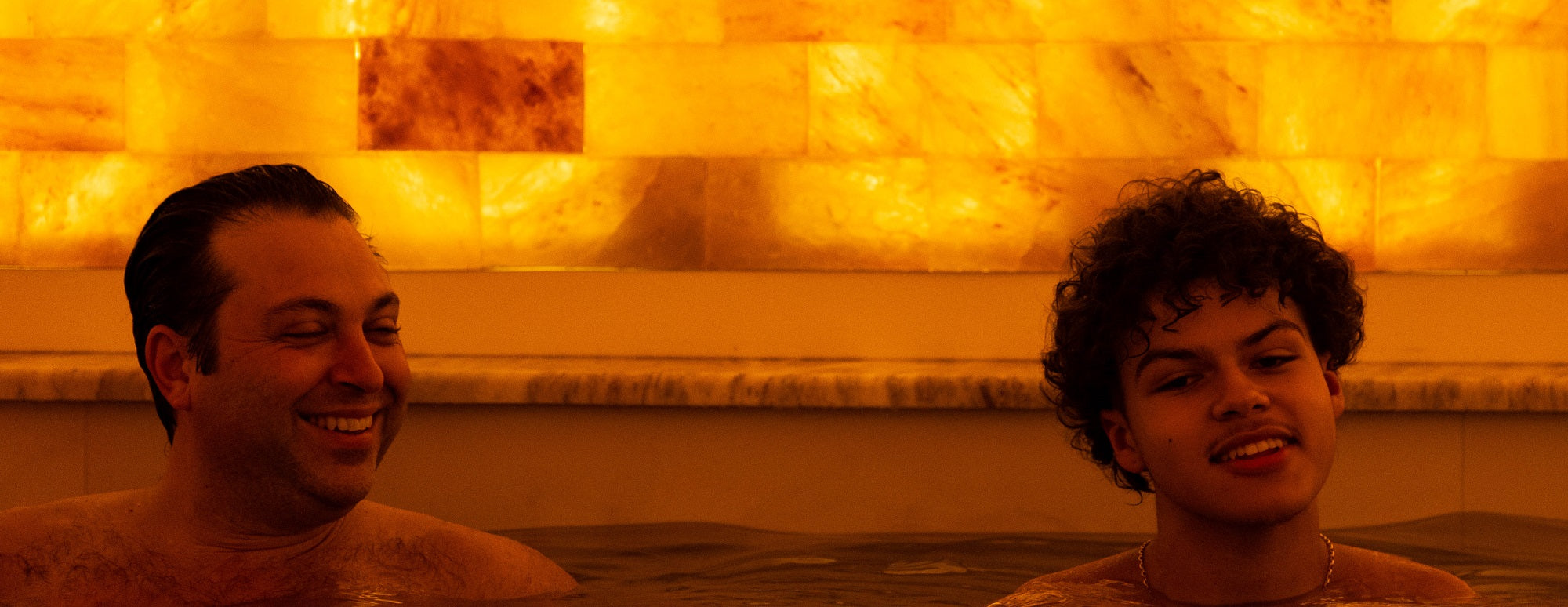 Two men relaxing in the Mineral bath, smiling and relaxed