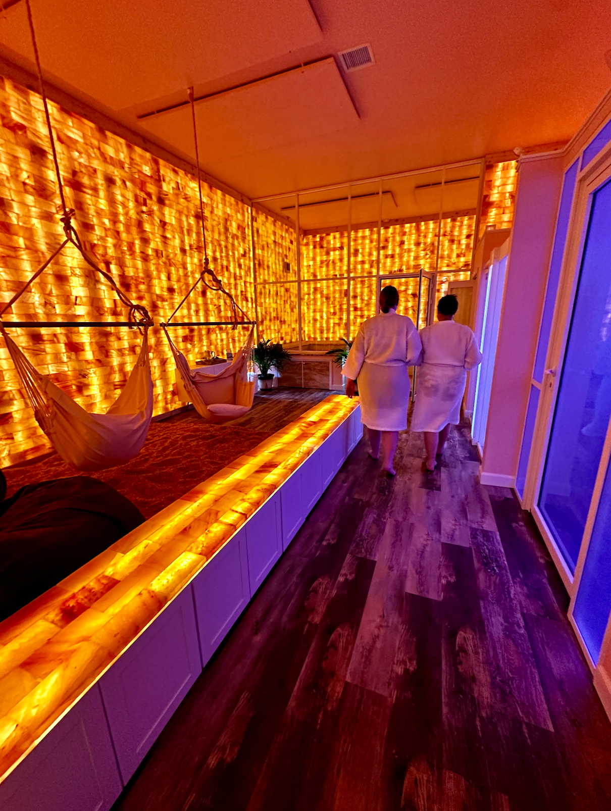 Two women walking with robes into the Himalayan Salt Room at The Spa Club